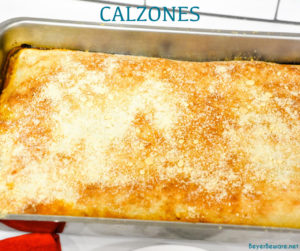 Deep-Dish Pan Calzones are a stuffed pizza recipe using a large thin pizza dough that literally wraps your favorite pizza toppings in dough in a 13x9 pan.