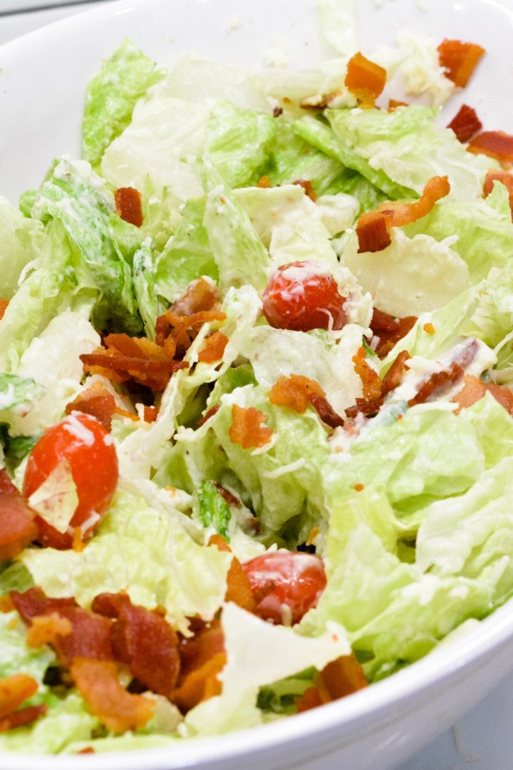 BLT salad is a simple salad recipe combining lettuce, tomatoes, mozzarella cheese, and bacon crumbles with a homemade creamy dressing that is a cross between ranch and caesar dressing.