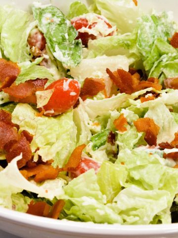 BLT salad is a simple salad recipe combining lettuce, tomatoes, mozzarella cheese, and bacon crumbles with a homemade creamy dressing that is a cross between ranch and caesar dressing.