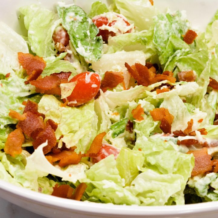 BLT salad is a simple salad recipe combining lettuce, tomatoes, mozzarella cheese, and bacon crumbles with a homemade creamy dressing that is a cross between ranch and caesar dressing.