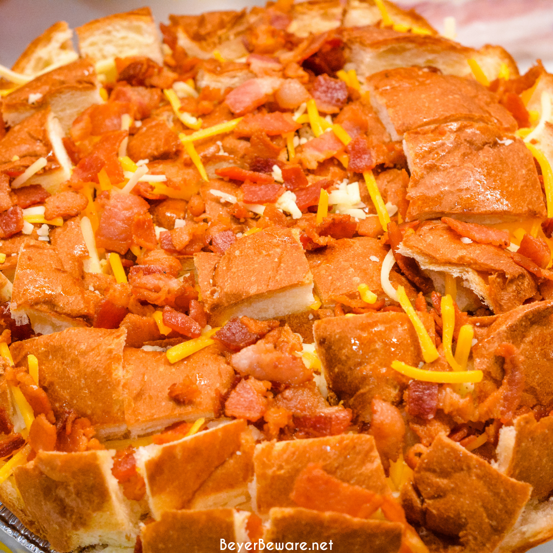 The cheesy ranch bacon pull-apart bread recipe is an easy appetizer made with a Hawaiian Bread round loaf that is filled with bacon, cheese, and, green onions ranch butter then baked to gooey crack bread perfection.