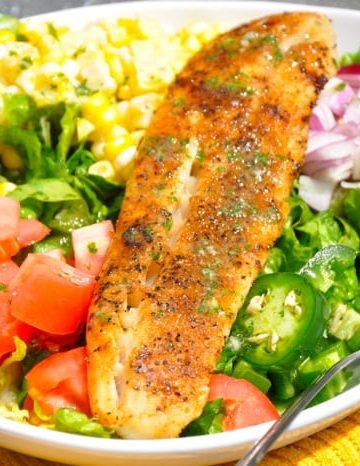 Blackened Fish Taco Salad recipe is a refreshing blend your favorite veggies and meat for a taco salad and dressed in a cilantro lime dressing.