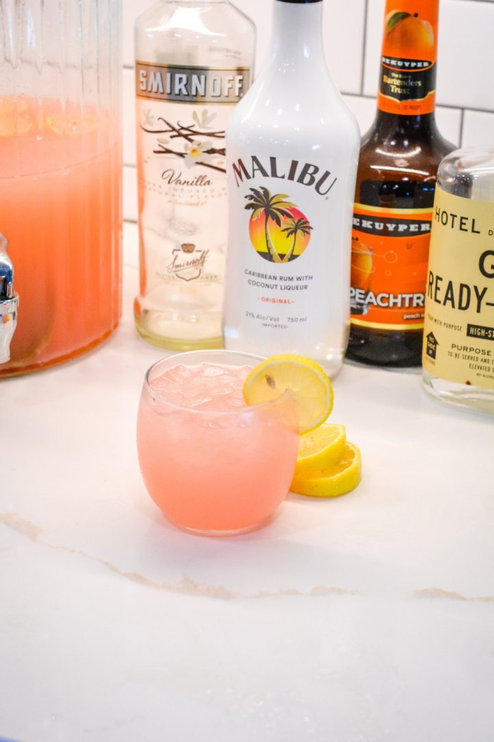 An easy spiked island lemonade recipe mixing country time pink lemonade, Malibu rum, vodka, gin, and peach schnapps.