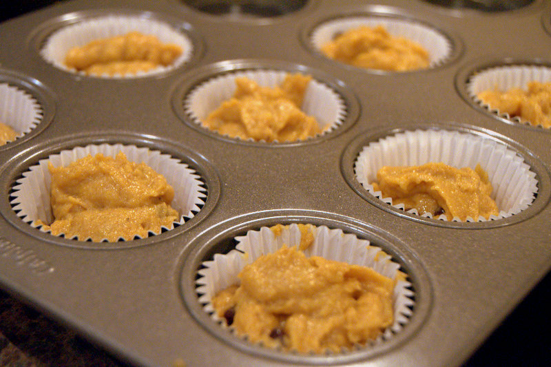 muffin tins filled with pumpkin muffin batter