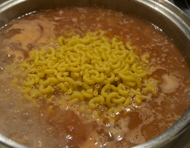 uncooked macaroni to ground beef mixture