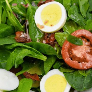 Spinach salad with hot bacon dressing is an easy spinach salad recipe made with bacon, tomatoes, and eggs tossed in a warm dressing that has a mixture of tangy sweetness and salty from the bacon. #bacon #spinach #salad #bacon #BaconDressing #SpinachSalad #EasterRecipes #keto