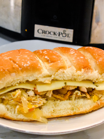 Crock pot chicken philly sandwiches are an easy pulled chicken sandwiches made with onion, peppers, chicken, steak seasoning, and butter.