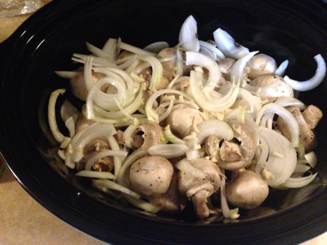 Mushrooms and onions in a crock pot.