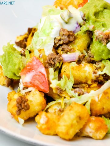 Totchos are the tater tot version of nachos with all your favorite taco toppings like ground beef, lettuce, tomatoes, and cheese.