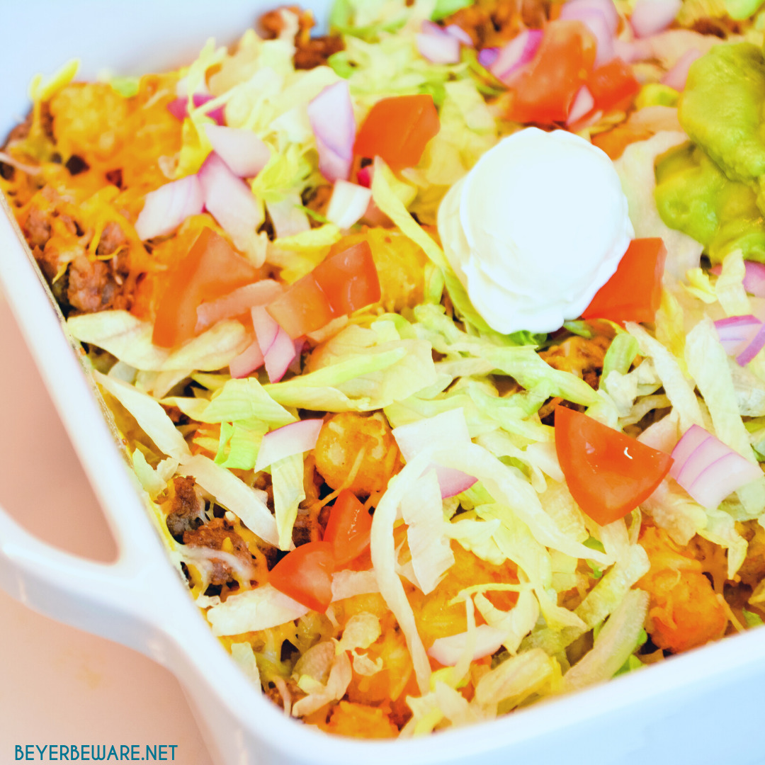 Totchos are the tater tot version of nachos with all your favorite taco toppings like ground beef, lettuce, tomatoes, and cheese.