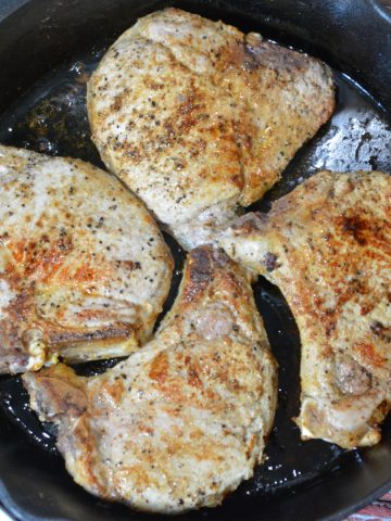 Pan-Fried pork chops recipe has no flour, no marinading, no waiting, just juicy, flavorful pork chops cooked in a buttered cast iron skillet.