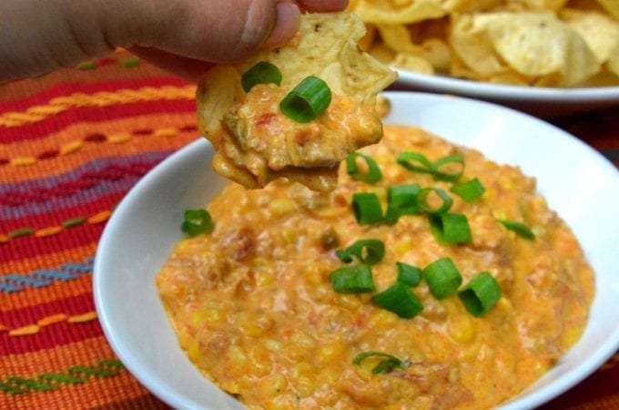 This crock pot corn and sausage queso dip is spicy from the addition of chorizo with a hint of sweet from the corn sure to make it your new favorite cheese queso dip recipe.