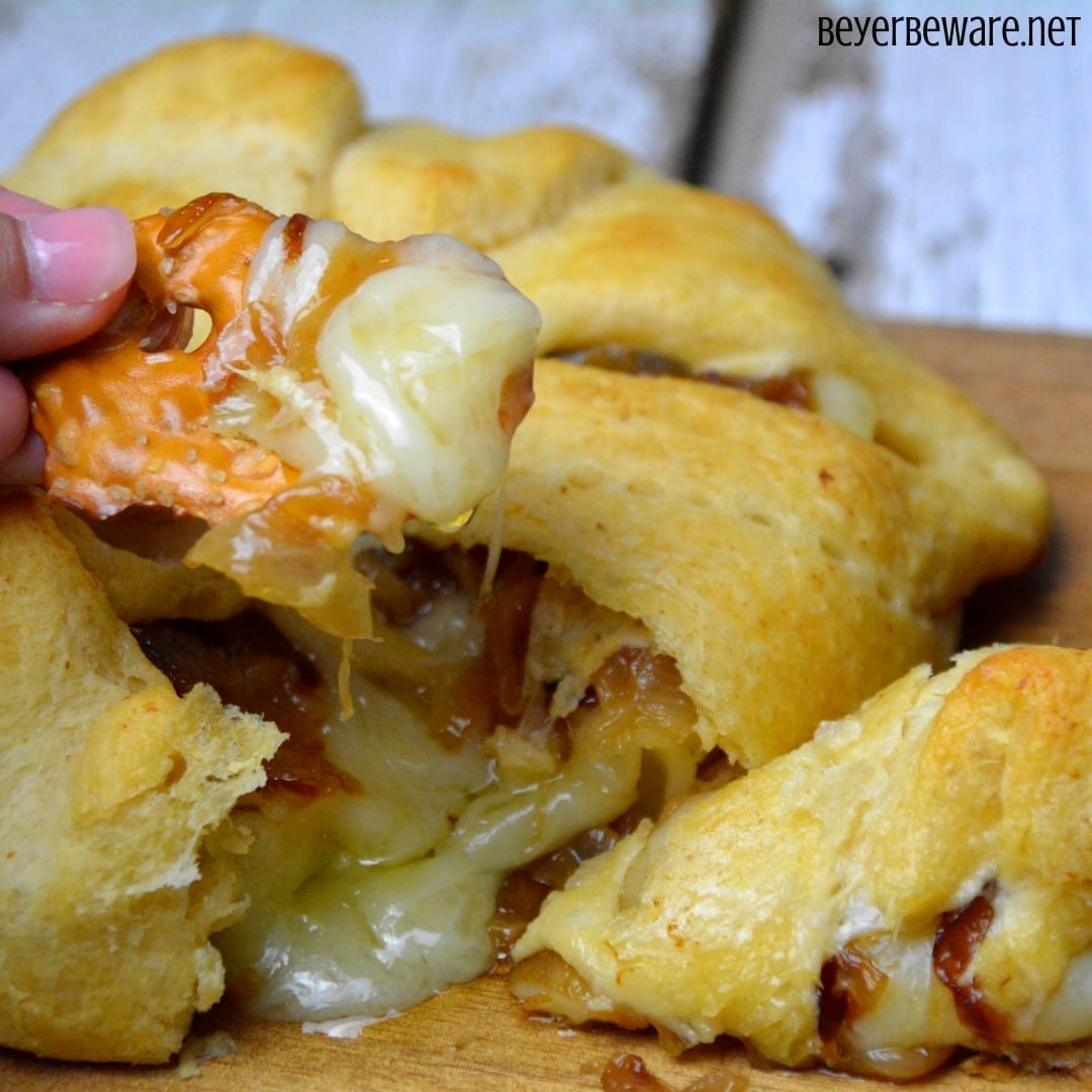 Caramelized onion baked brie crescent round is a simple combination of butter and onions browned until caramelized and piled into a brie round wrapped in crescent rounds. #brie #BakedBrie #Appetizers