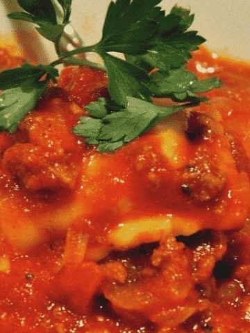 Meaty Tomato Ravioli Soup is a 30-minute meal combing ground beef, canned tomatoes, ravioli and parmesan cheese for a hearty and easy dinner recipe. #soup #Ravioli #EasyDinnerRecipe