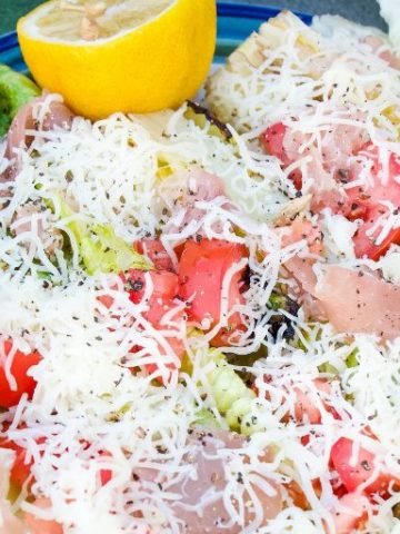 Grilled romaine salad topped with prosciutto, tomatoes, cheese and lemon juice & olive oil is the perfect BBQ side dish all summer long. #Salad #Grilling #lettuce #sidedish #Recipes