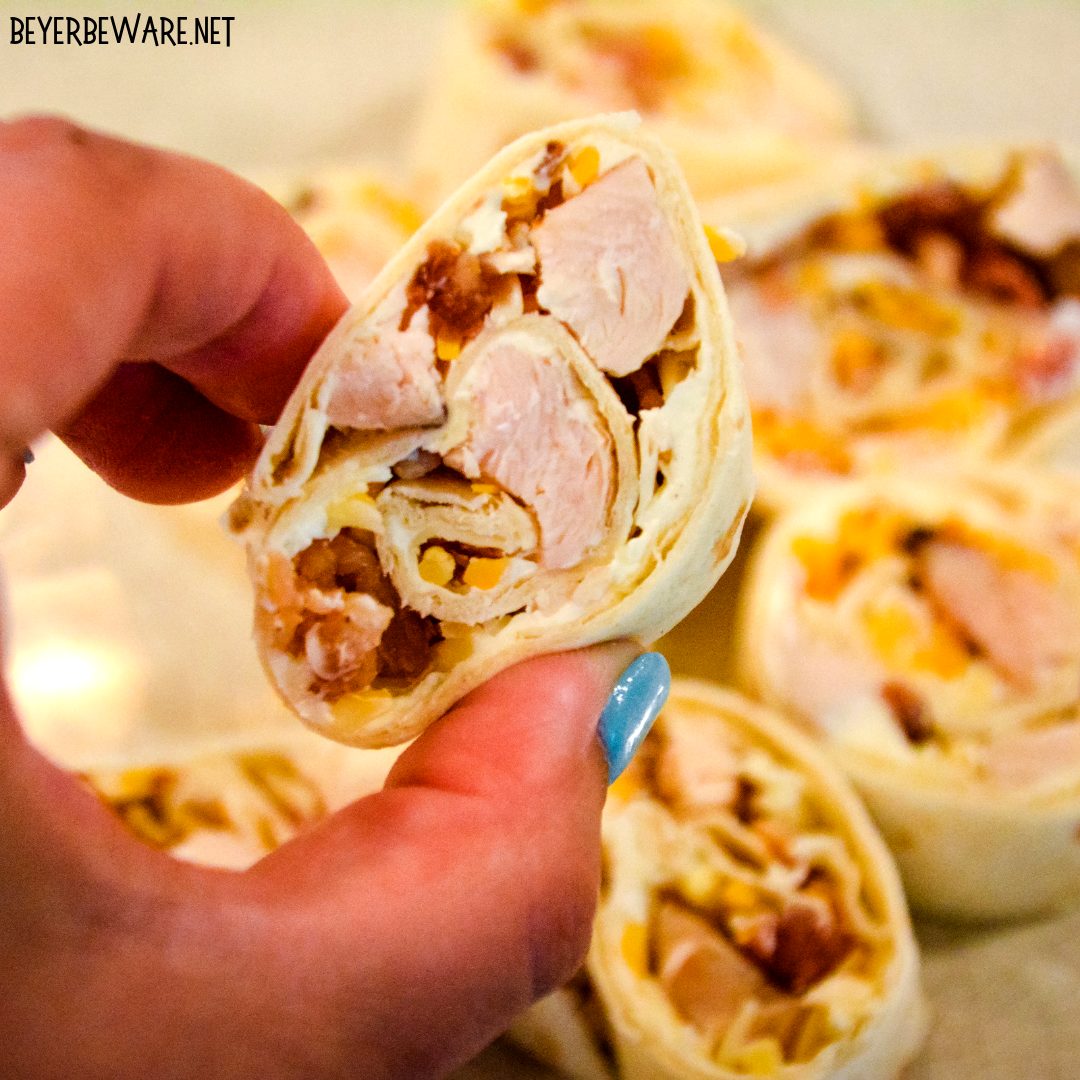 Chicken bacon ranch roll-ups are a quick tortilla wrapped sandwich recipe filled with ranch flavored cream cheese, cubed chicken, bacon, and cheese and sliced into pinwheels. 
