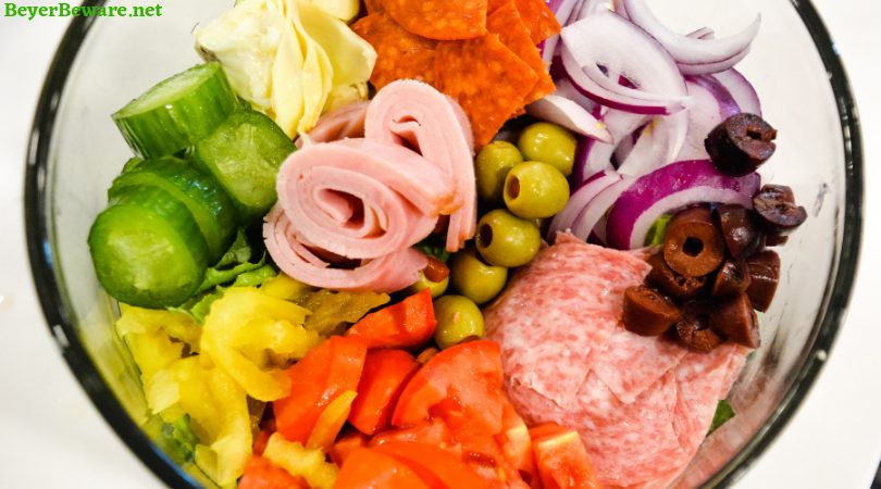 Italian antipasto salad is a hearty dinner salad with a romaine lettuce base and filled up with salami, pepperoni, tomatoes, cucumbers, onions, olives, banana peppers, artichoke hearts and cheese dressed with a homemade Italian dressing.