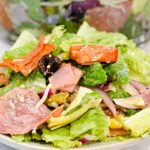 Italian antipasto salad is a hearty dinner salad with a romaine lettuce base and filled up with salami, pepperoni, tomatoes, cucumbers, onions, olives, banana peppers, and cheese dressed with a homemade Italian dressing.