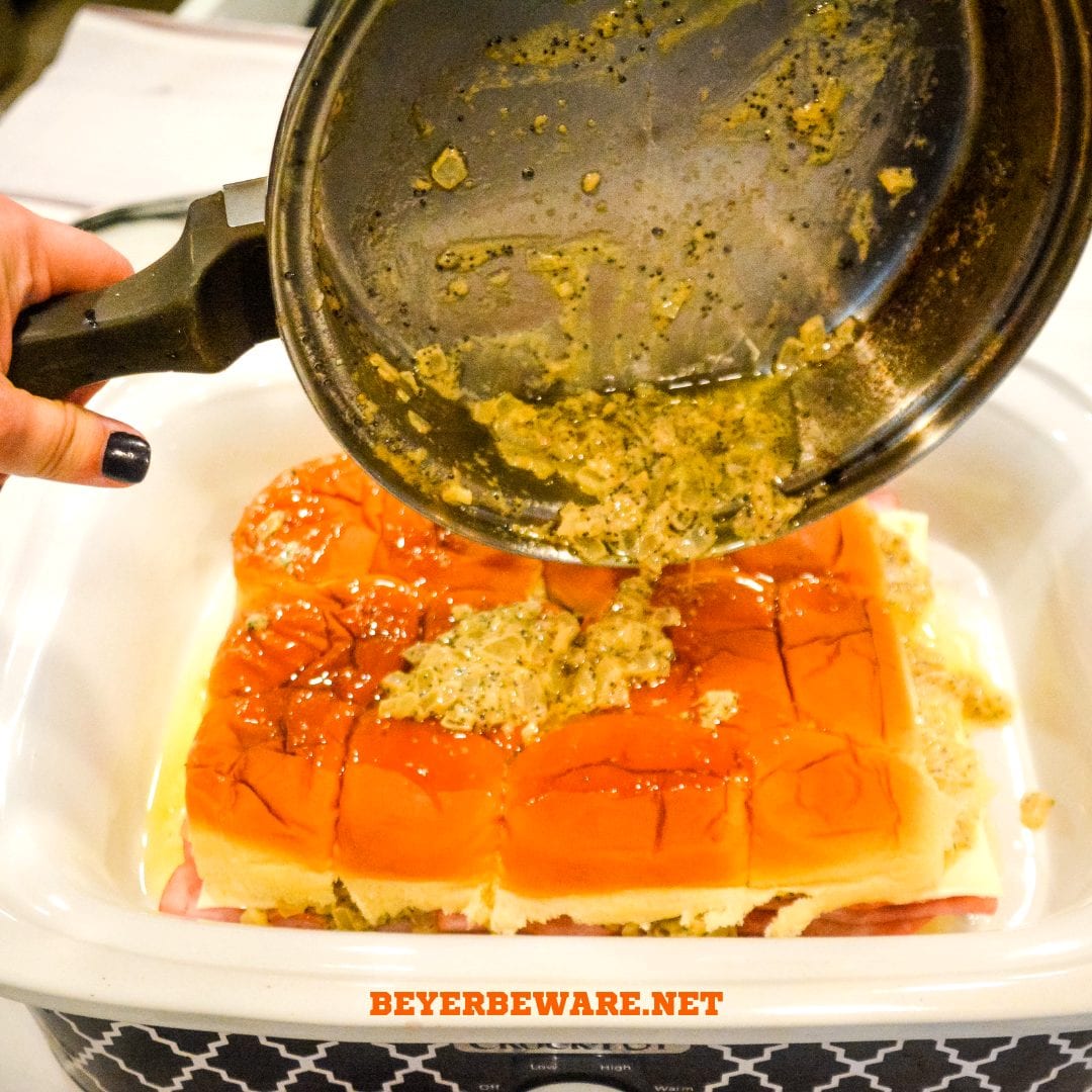 Crock pot Hawaiian roll ham sandwiches are the warm buttery mustard ham sandwich recipe made with onions, poppy seeds, and Swiss cheese without needing to bake them with the same results.