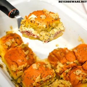 Crock pot Hawaiian roll ham sandwiches are the warm buttery mustard ham sandwich recipe made with onions, poppy seeds, and Swiss cheese without needing to bake them with the same results.