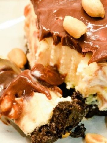 Peanut buster parfait ice cream dessert is a 13X9 ice cream cake with layers of crushed Oreos, vanilla ice cream, peanuts, and homemade chocolate sauce. 