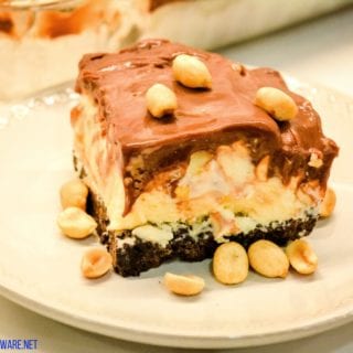 Peanut buster parfait ice cream dessert is a 13X9 ice cream cake with layers of crushed Oreos, vanilla ice cream, peanuts, and homemade chocolate sauce. 