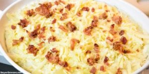 Keto loaded mashed cauliflower casserole is loaded with white cheddar cheese and bacon while made smooth as mashed potatoes with sour cream and cream cheese as it bakes to perfection. #Keto #LowCarb #KetoSideDishes #KetoRecipes #Recipes #Cauliflower