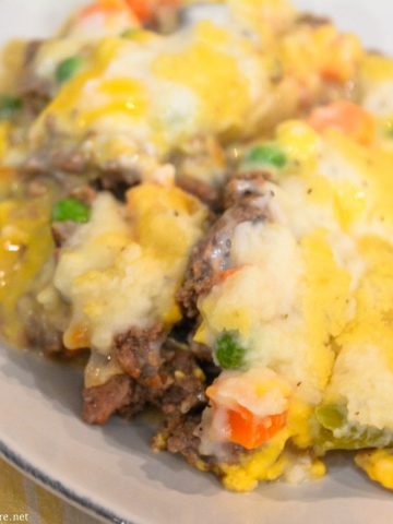 Cheesy Shepherd's Pie is a ground beef casserole filled with mixed vegetables, cheese, cream of mushroom soup, and topped off with mashed potatoes.