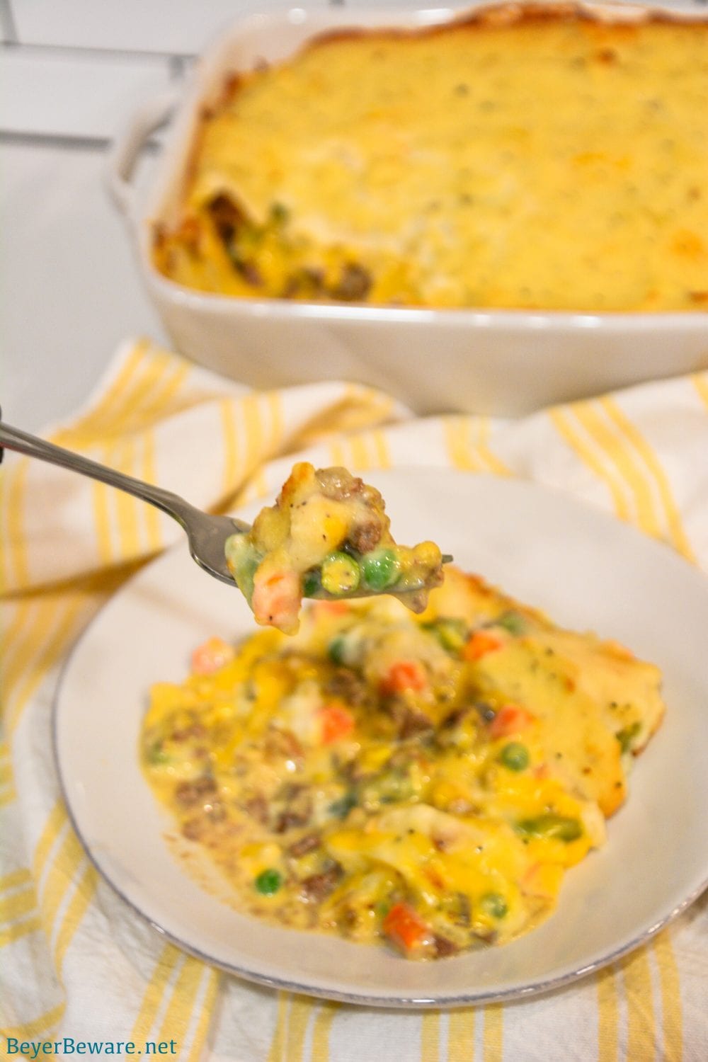 Cheesy Shepherd's Pie is a ground beef casserole filled with mixed vegetables, cheese, cream of mushroom soup, and topped off with mashed potatoes.