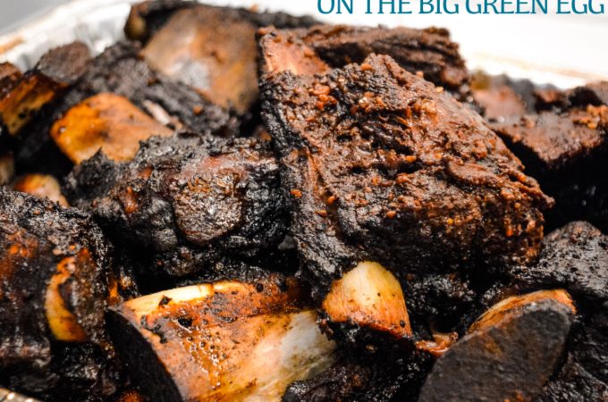 Grilled beef short ribs on the Big Green Egg are smoked with a beef barbecue rub and then slow-cooked to their final temperature in a bath of red wine, butter, and beef broth.