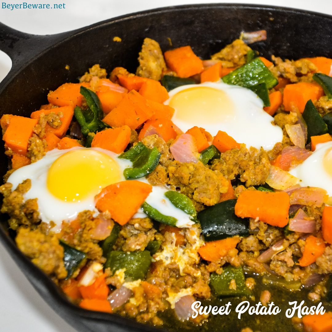 Sweet potato hash with sausage and eggs is a hearty breakfast skillet made with diced sweet potatoes, spicy sausage, onions, and poblano peppers with fried or poached eggs over the top.