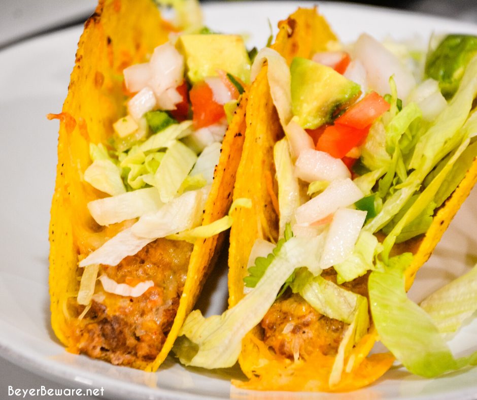 Two ground beef baked tacos with toppings