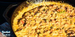 Smoked queso is your favorite queso dip made with Velveeta, Rotel, onions, taco meat, and peppers made in a cast-iron skillet on your smoker or grill.