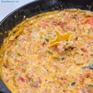 Smoked queso is your favorite queso dip made with Velveeta, Rotel, onions, taco meat, and peppers made in a cast-iron skillet on your smoker or grill.