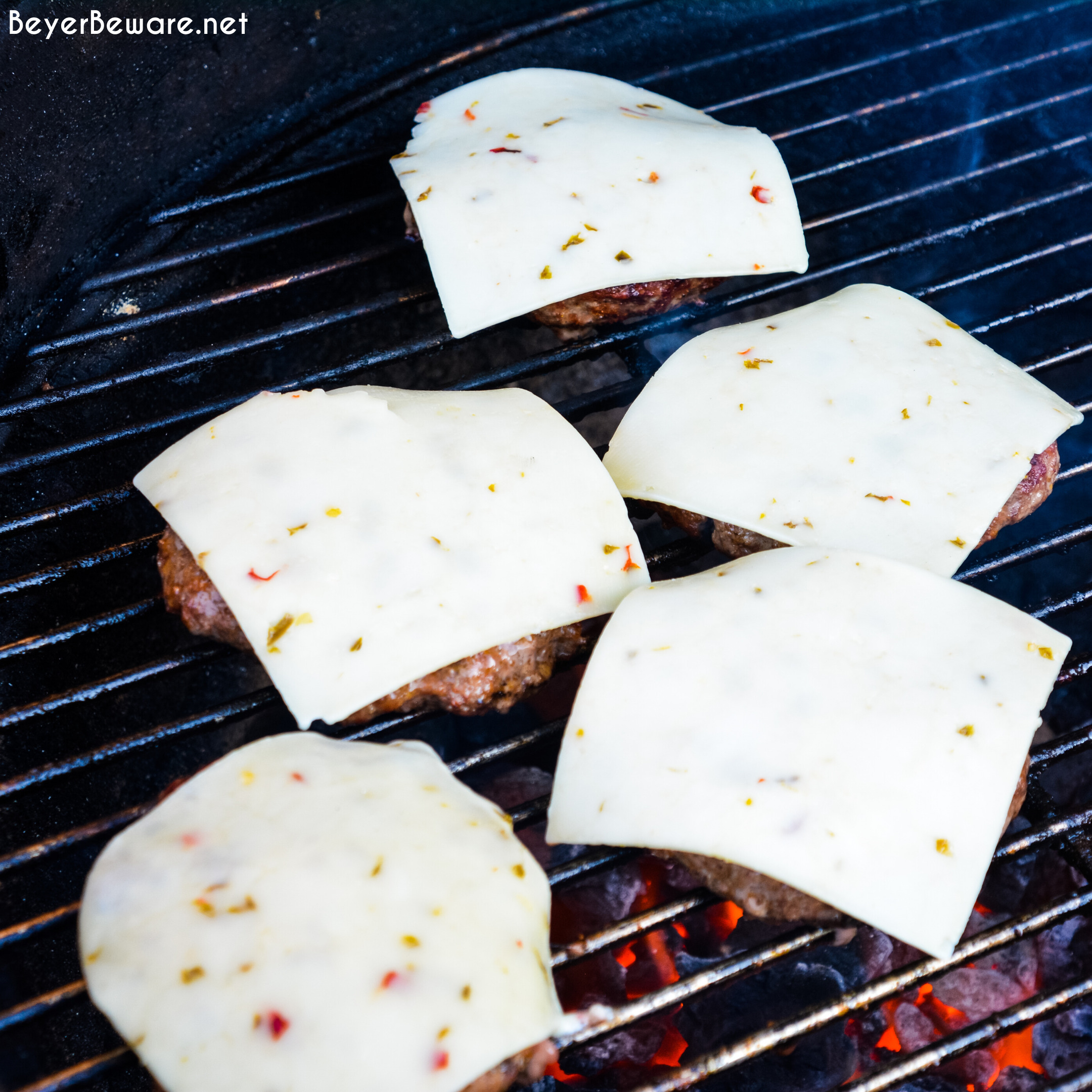 Guacamole burgers combine taco night with burger night straight from the grill with flavorful burgers, pepper-jack cheese, guacamole, sauteed onions, peppers, and street taco tortilla shells.