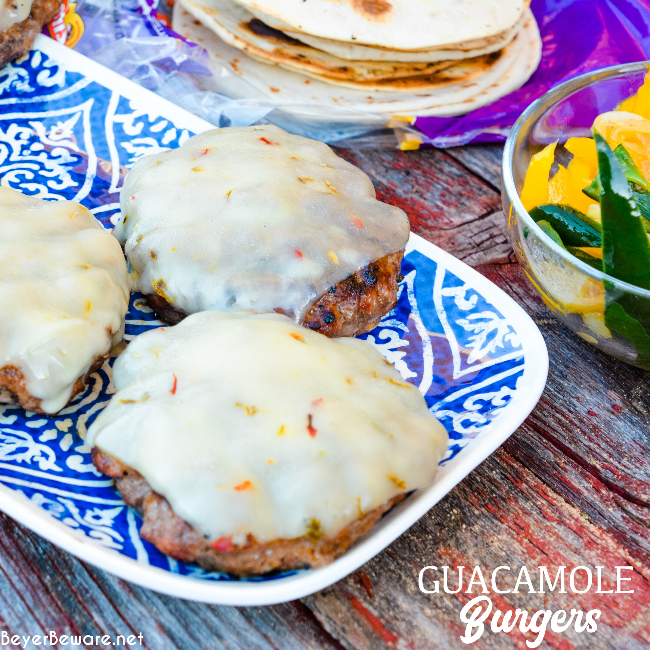 Guacamole burgers combine taco night with burger night straight from the grill with flavorful burgers, pepper-jack cheese, guacamole, sauteed onions, peppers, and street taco tortilla shells.