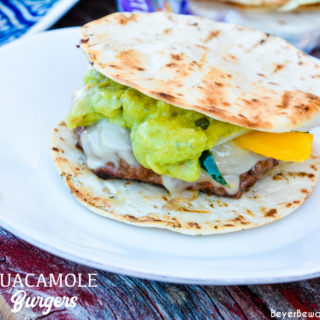 Guacamole burgers combine taco night with burger night straight from the grill with flavorful burgers, pepper-jack cheese, guacamole, sauteed onions, peppers, and street taco tortilla shells.