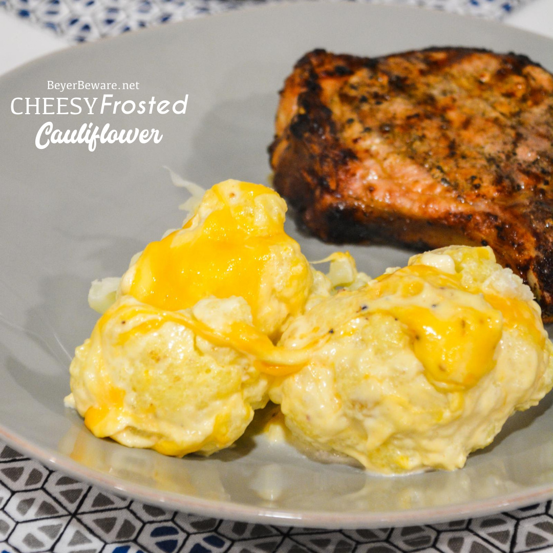 Cheesy Frosted Cauliflower is a whole head of cauliflower, steamed and then frosted with a combination of mayonnaise and mustard and then covered in cheese before quickly roasting in the oven.