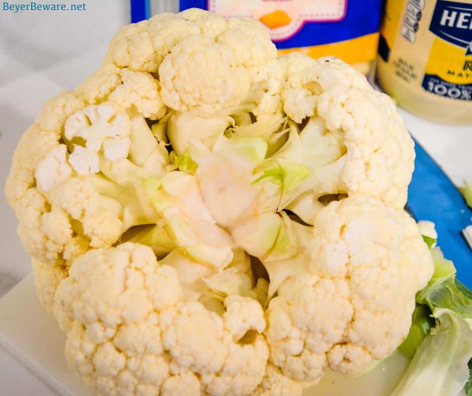 Cheesy Frosted Cauliflower is a whole head of cauliflower, steamed and then frosted with a combination of mayonnaise and mustard and then covered in cheese before quickly roasting in the oven.