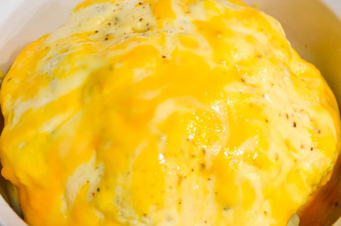 Cheesy Frosted Cauliflower is a whole head of cauliflower, steamed and then frosted with a combination of mayonnaise and mustard and then covered in cheese before quickly roasting in the oven.