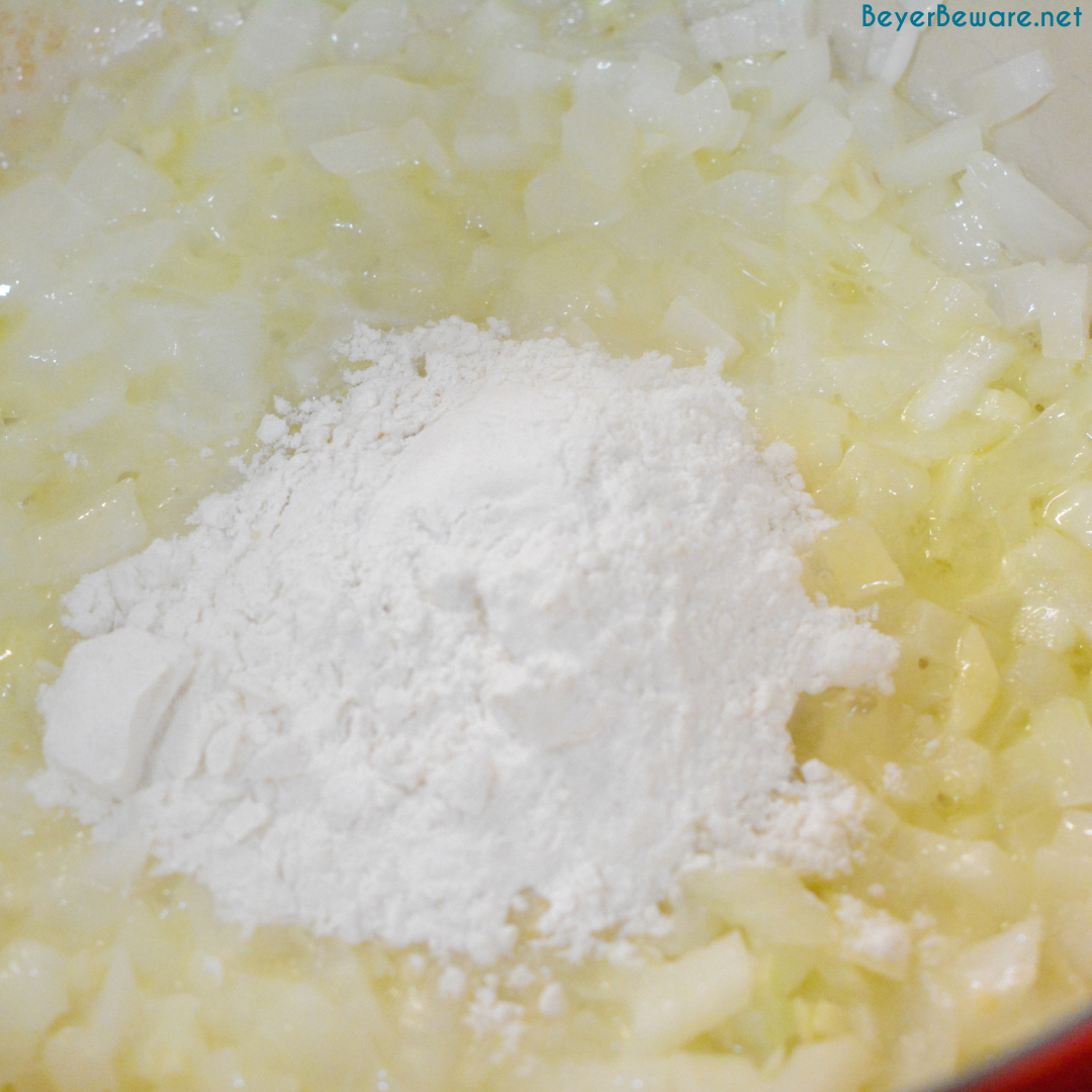 Making a roux with butter, onions, garlic, and four.