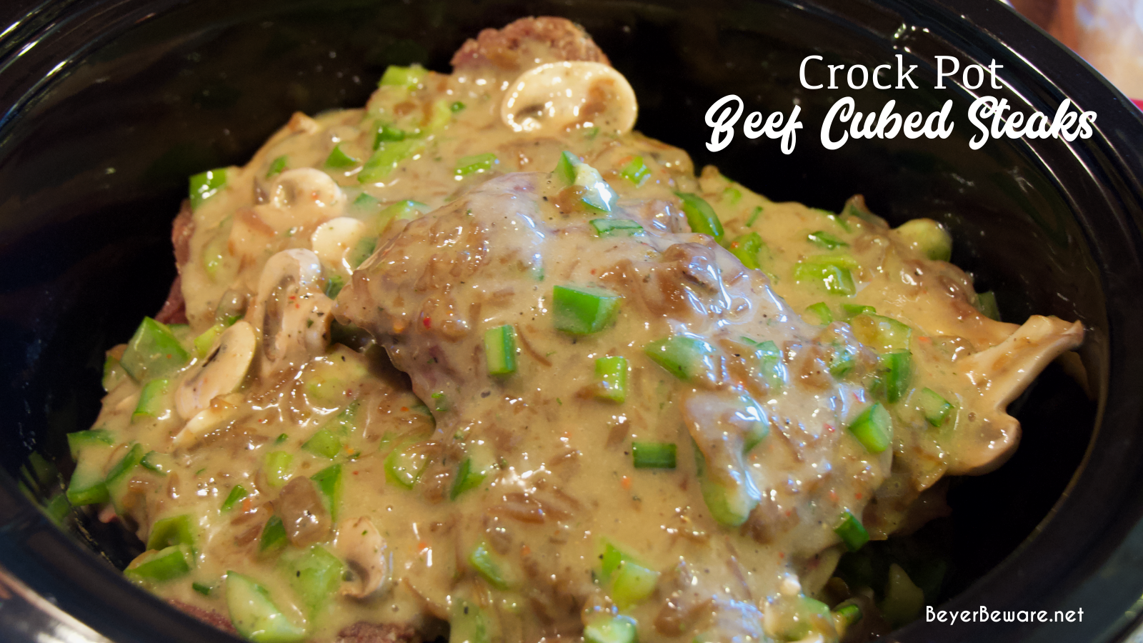 Crock pot beef cubed steak with gravy is a simple recipe that combines ranch and Italian seasoning and cream of mushroom soup and French onion soup with mushrooms, onions, and peppers for a tender cubed steak recipe that is perfect over mashed potatoes.