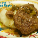 Crock pot beef cubed steak with gravy is a simple recipe that combines ranch and Italian seasoning and cream of mushroom soup and French onion soup with mushrooms, onions, and peppers for a tender cubed steak recipe that is perfect over mashed potatoes.