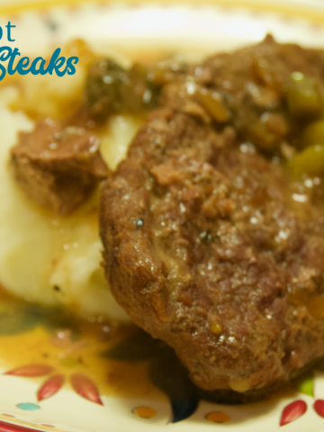 Crock pot beef cubed steak with gravy is a simple recipe that combines ranch and Italian seasoning and cream of mushroom soup and French onion soup with mushrooms, onions, and peppers for a tender cubed steak recipe that is perfect over mashed potatoes.