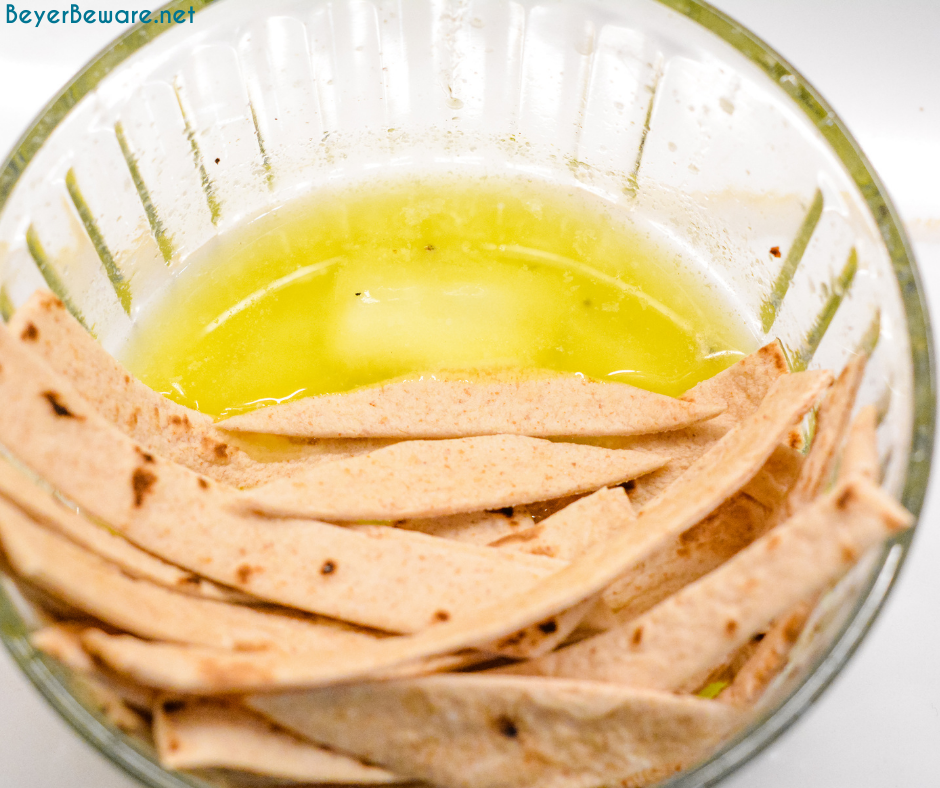 Dipping tortilla strips into kmelted butter.