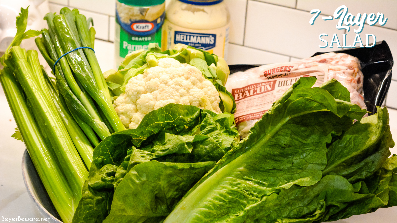 7 layer salad is my grandmother's version of overnight lettuce salad made with lettuce, cauliflower, mayonnaise, onions, celery, bacon, and parmesan cheese.