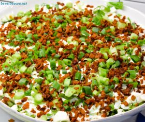 Overnight lettuce salad is my grandmother's version of 7 layer salad made with lettuce, cauliflower, mayonnaise, onions, celery, bacon, and parmesan cheese.