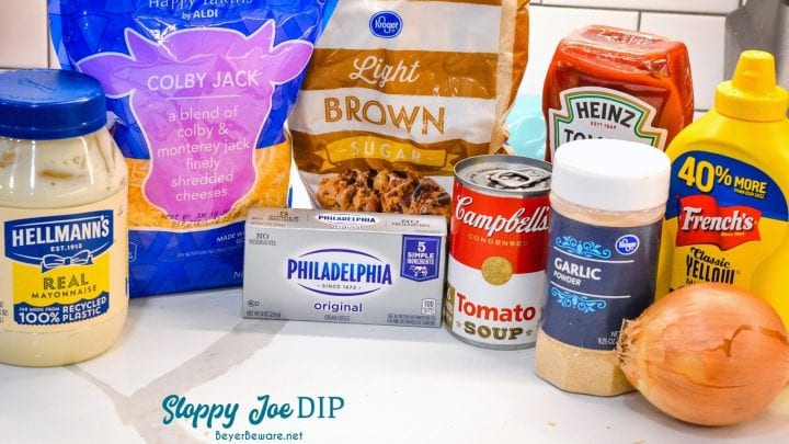 Sloppy Joe Dip has a cream cheese base and topped with an easy sloppy joe ground beef mixture and topped off with shredded cheese and onions, baked to a gooey, meaty goodness and then scooped up with corn chips.