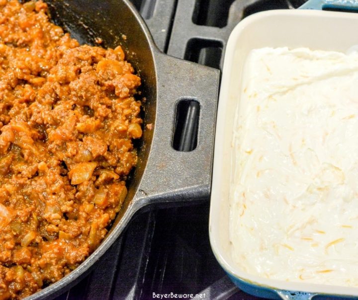 Sloppy Joe Dip has a cream cheese base and topped with an easy sloppy joe ground beef mixture and topped off with shredded cheese and onions, baked to a gooey, meaty goodness and then scooped up with corn chips.