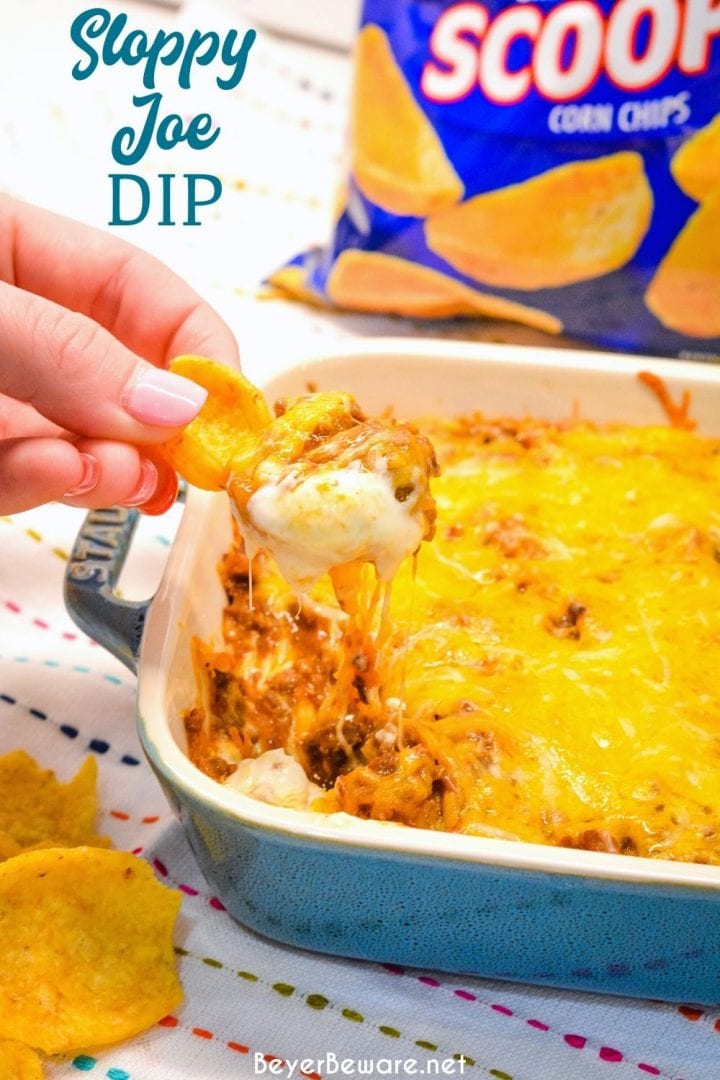 Sloppy Joe Dip has a cream cheese base and topped with an easy sloppy joe ground beef mixture and topped off with shredded cheese and onions, baked to a gooey, meaty goodness and then scooped up with corn chips.